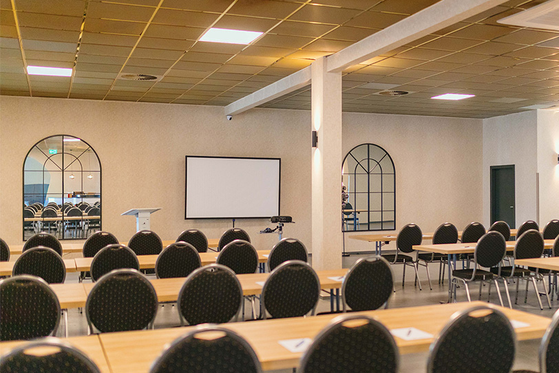 Stuhlreihen und Tische für Seminare