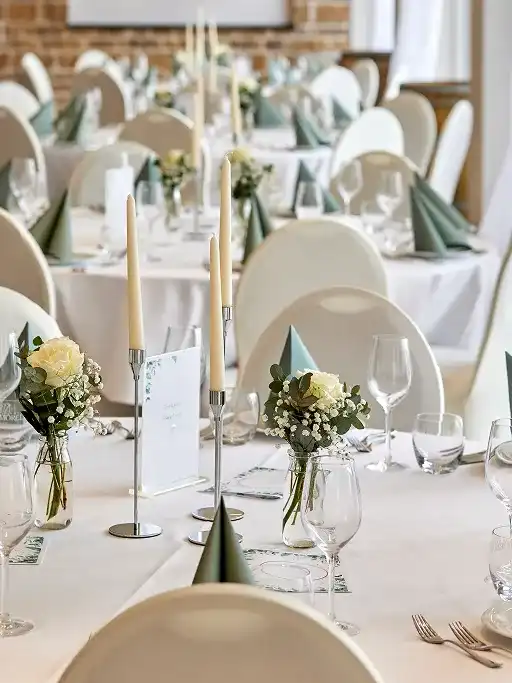 Gedeckte Tafel mit Kerzen und Blumen