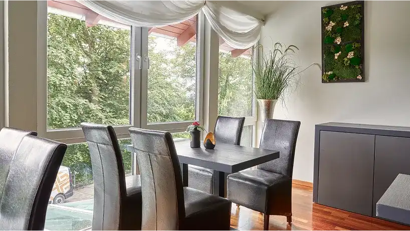 Fensterfront mit Sitzgruppe und Pflanzen